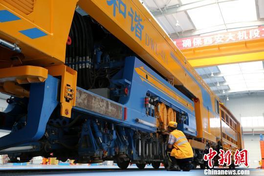圖為工人正在清理大型養(yǎng)路機(jī)械?！堖h(yuǎn) 攝